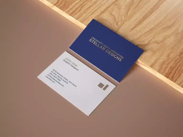 A luxurious business card design featuring a royal blue front with gold foil company name and slogan, and a white back with royal blue text, gold foil name, and logo.